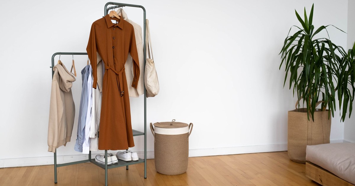 Portant de vêtements de seconde main immobile dans une pièce vide
